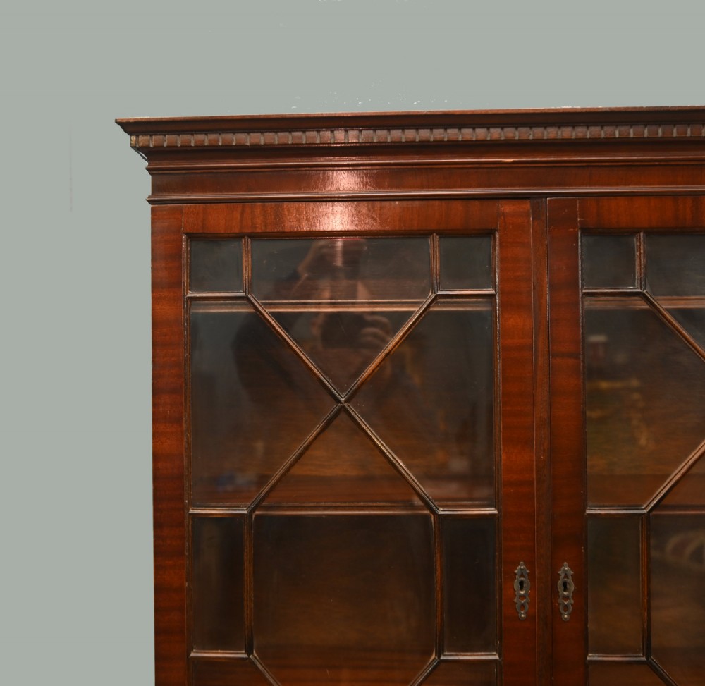 A Georgian Revival mahogany bookcase cabinet featuring a three-door astragal glazed upper section above three drawers and flame mahogany cupboard doors. View IV