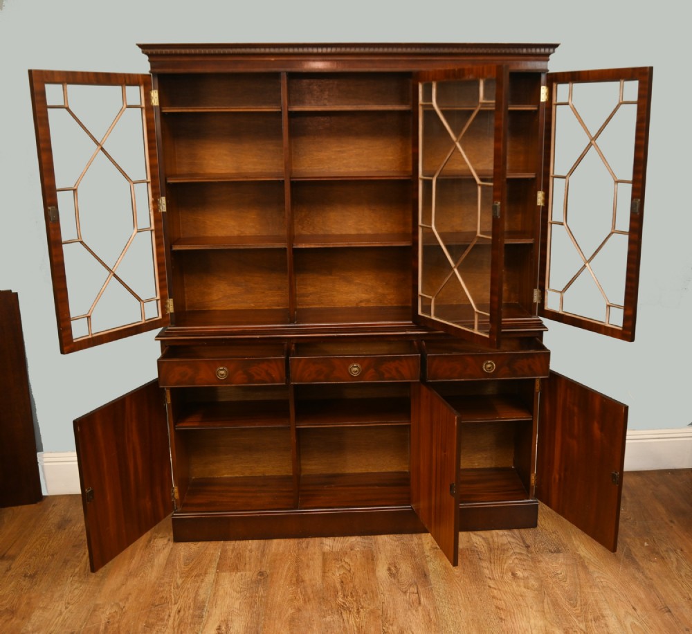 A Georgian Revival mahogany bookcase cabinet featuring a three-door astragal glazed upper section above three drawers and flame mahogany cupboard doors. View VI