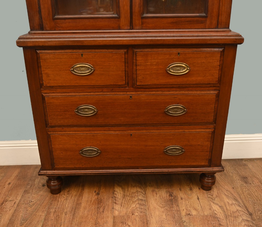 Victorian mahogany glazed bookcase featuring a two-door glass cabinet section resting on a chest of four drawers with brass handles. View III