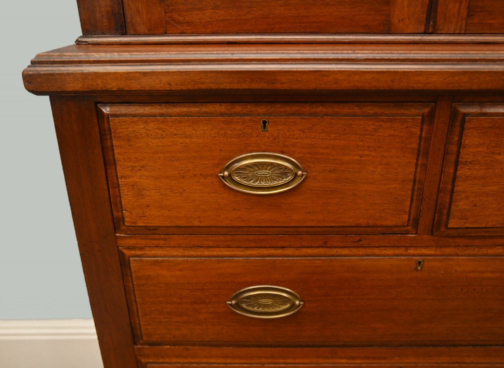 Victorian mahogany glazed bookcase featuring a two-door glass cabinet section resting on a chest of four drawers with brass handles. View IV