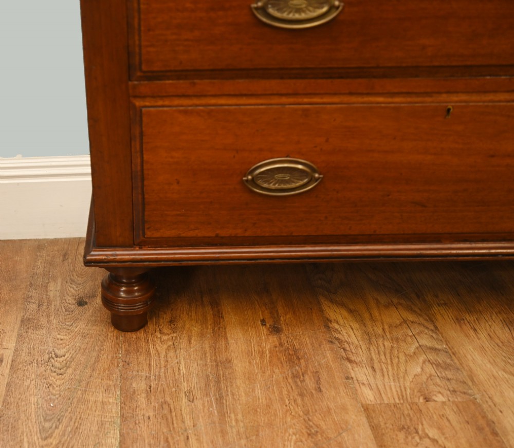 Victorian mahogany glazed bookcase featuring a two-door glass cabinet section resting on a chest of four drawers with brass handles. View V