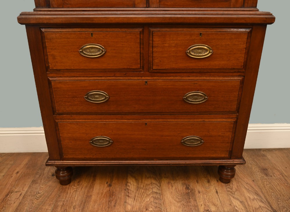 Victorian mahogany glazed bookcase featuring a two-door glass cabinet section resting on a chest of four drawers with brass handles. View VI