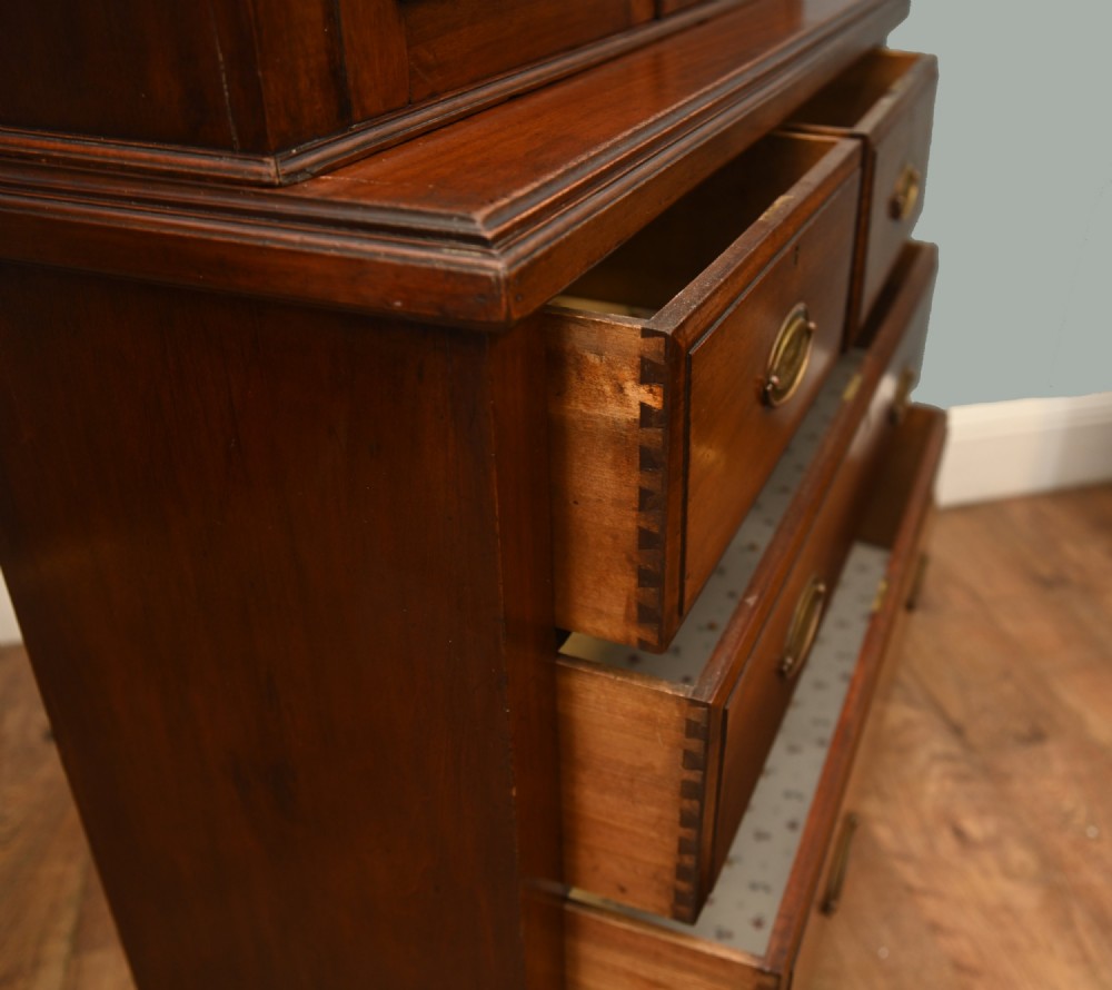 Victorian mahogany glazed bookcase featuring a two-door glass cabinet section resting on a chest of four drawers with brass handles. View VIII