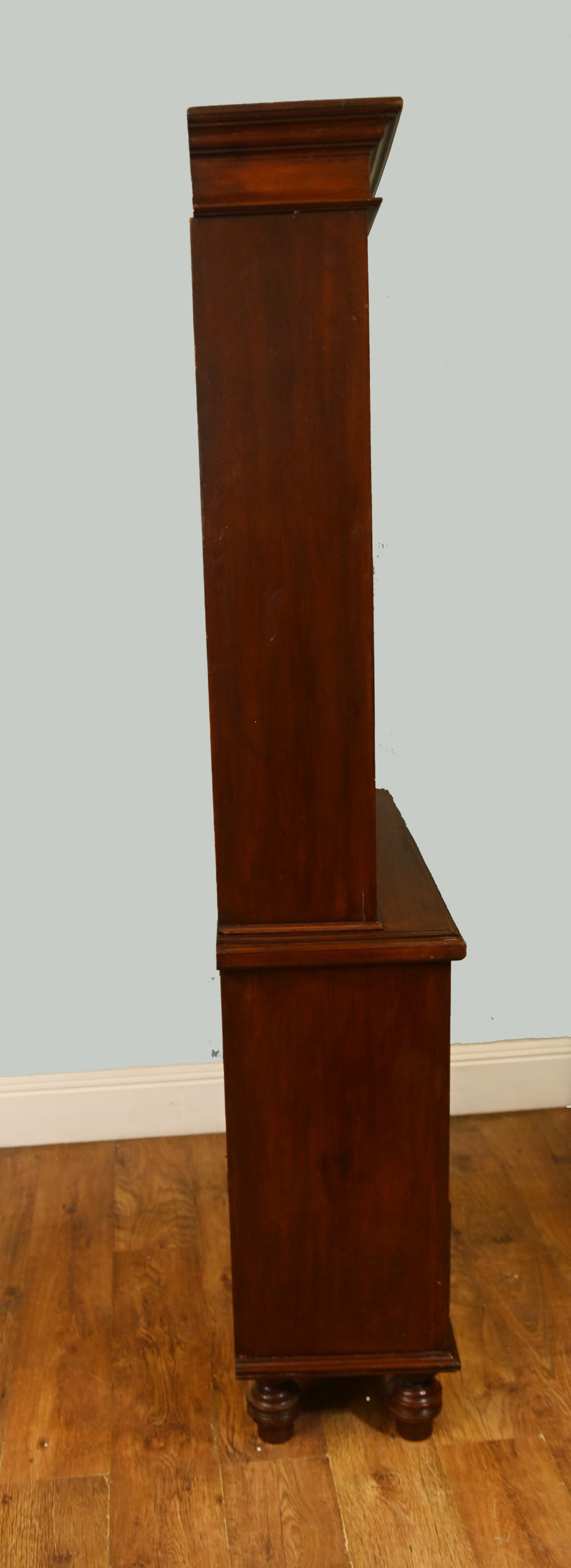 Victorian mahogany glazed bookcase featuring a two-door glass cabinet section resting on a chest of four drawers with brass handles. View IX