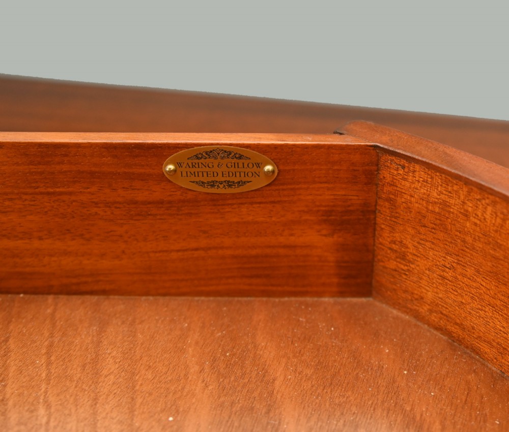 An Edwardian Sheraton Revival mahogany sideboard featuring satinwood oval inlay panels, crossbanded edging, brass ring handles, and square tapered legs. View X