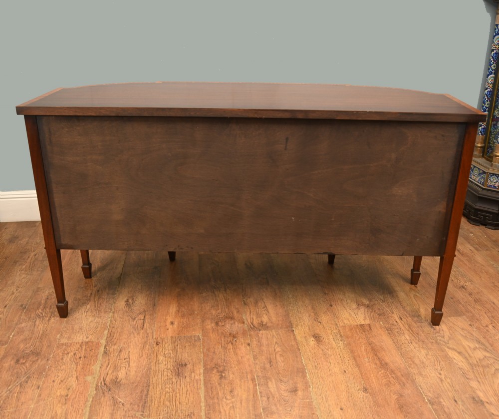 An Edwardian Sheraton Revival mahogany sideboard featuring satinwood oval inlay panels, crossbanded edging, brass ring handles, and square tapered legs. View XII