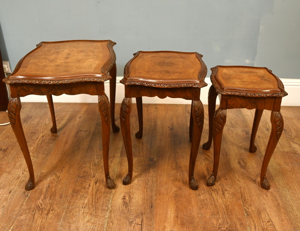 A set of three graduated burr walnut nest tables featuring carved serpentine edges, cabriole legs with carved knees, and claw-and-ball feet. View II