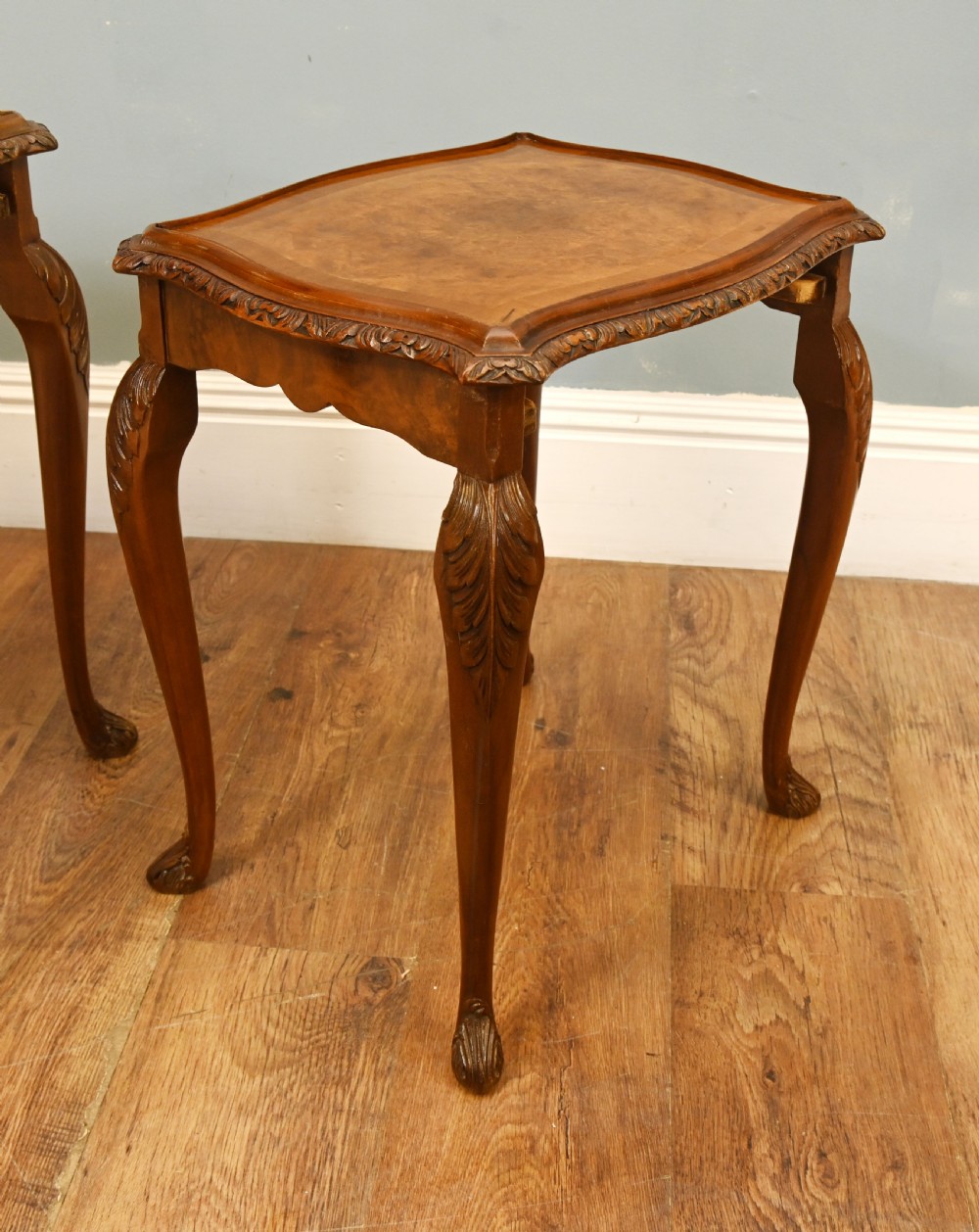 A set of three graduated burr walnut nest tables featuring carved serpentine edges, cabriole legs with carved knees, and claw-and-ball feet. View IV