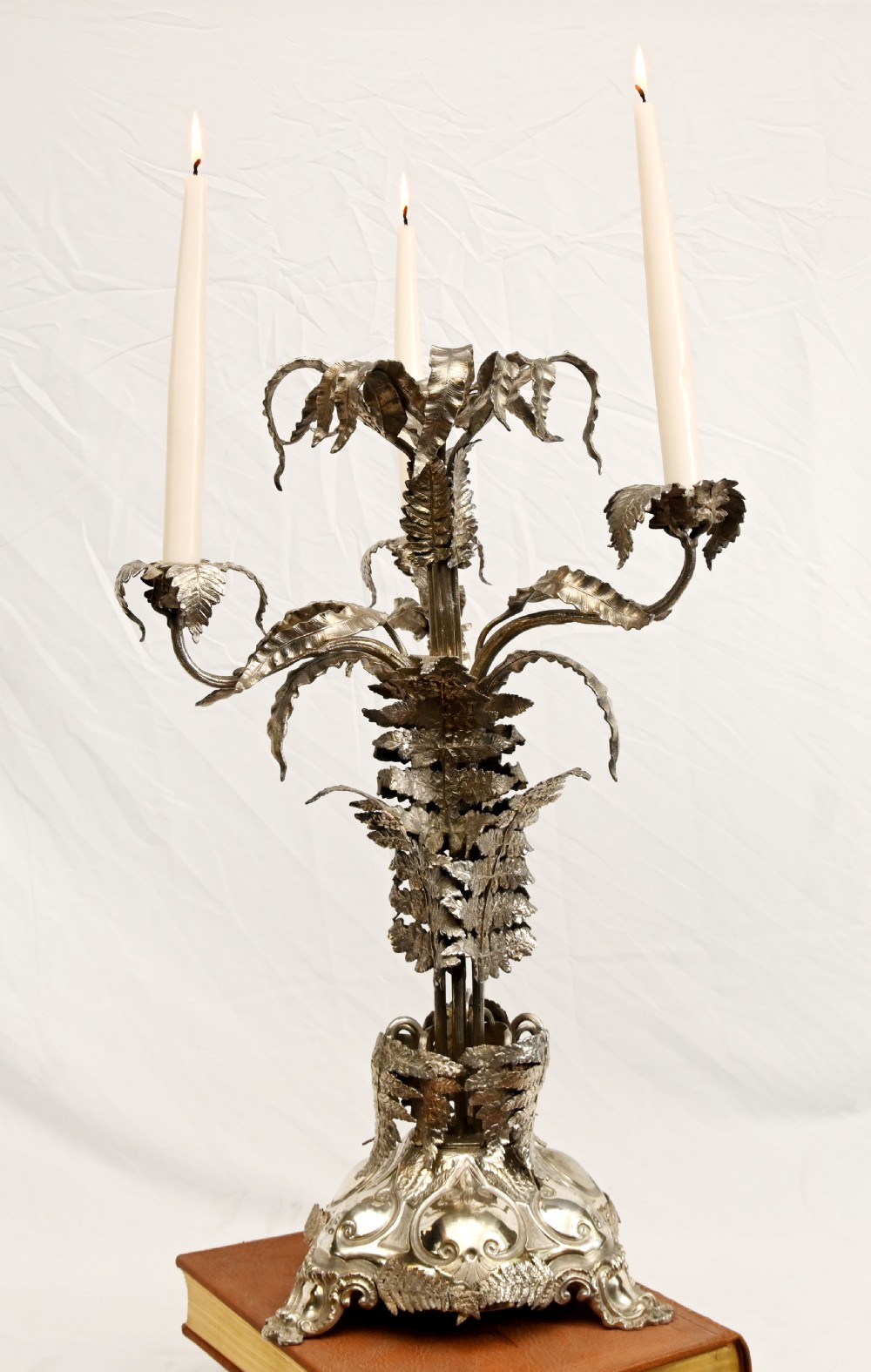 A silver-plated three-light candelabra designed in the shape of a palm tree with detailed foliate leaves and a scrolled base. View II