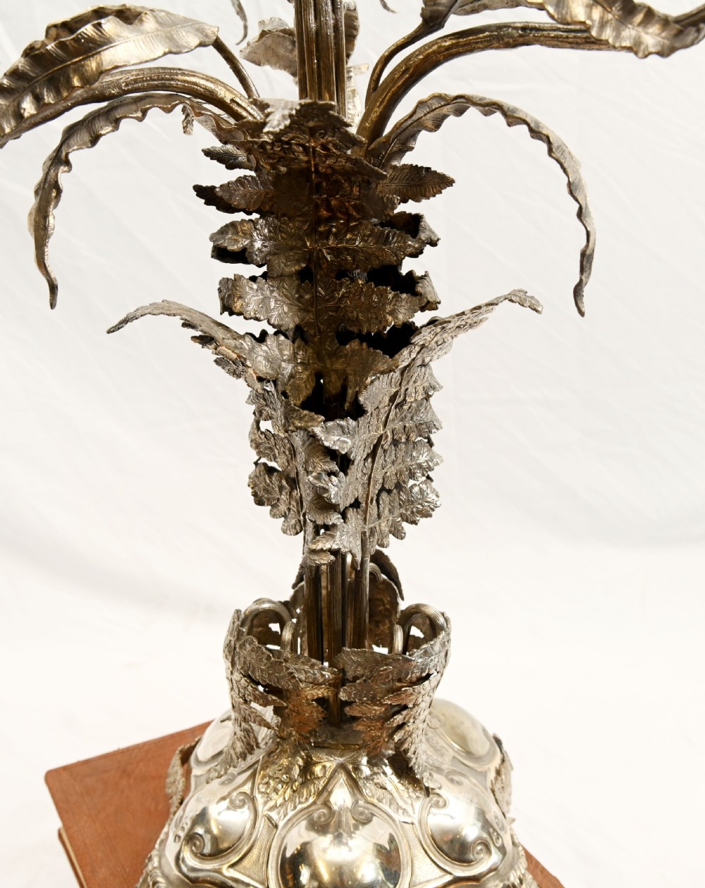 A silver-plated three-light candelabra designed in the shape of a palm tree with detailed foliate leaves and a scrolled base. View V