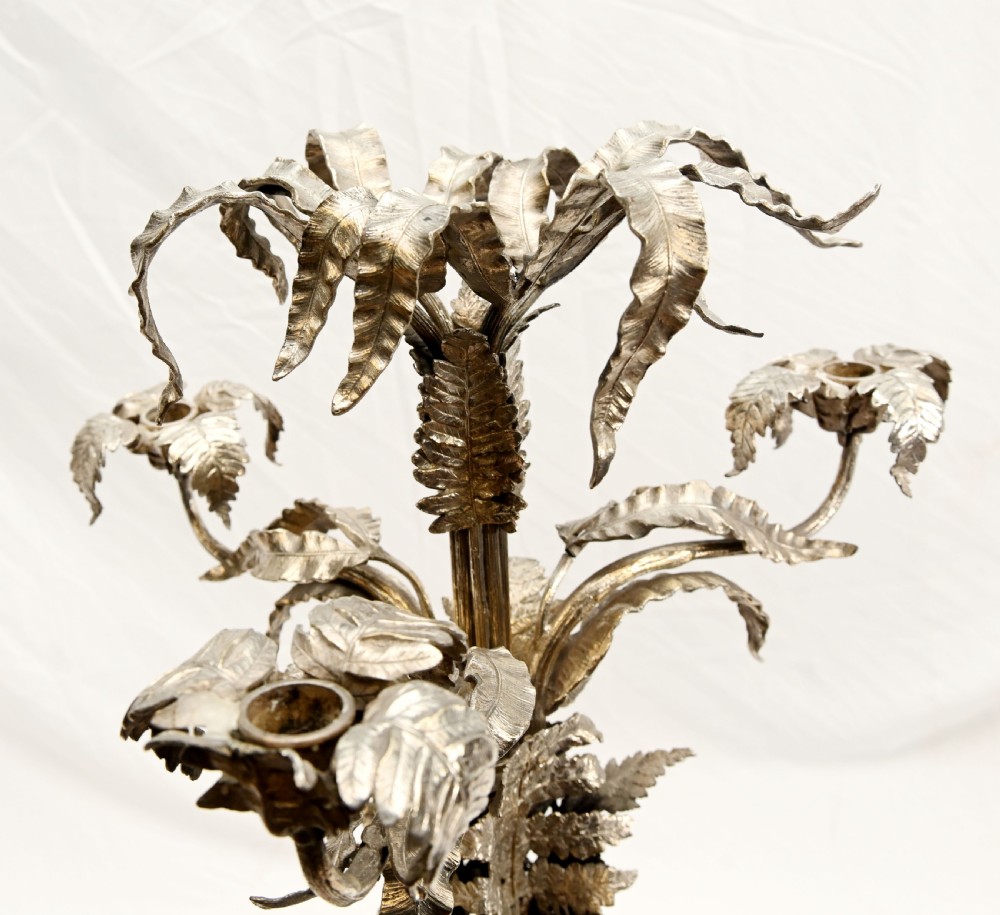 A silver-plated three-light candelabra designed in the shape of a palm tree with detailed foliate leaves and a scrolled base. View X