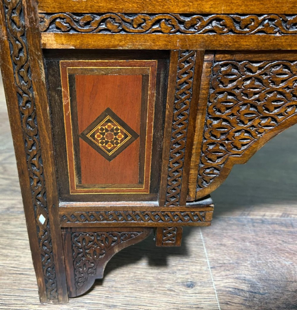 A pair of warm brown wooden armchairs featuring elaborate carved openwork crestings and geometric mother-of-pearl inlays across the seats and panels. View XIII