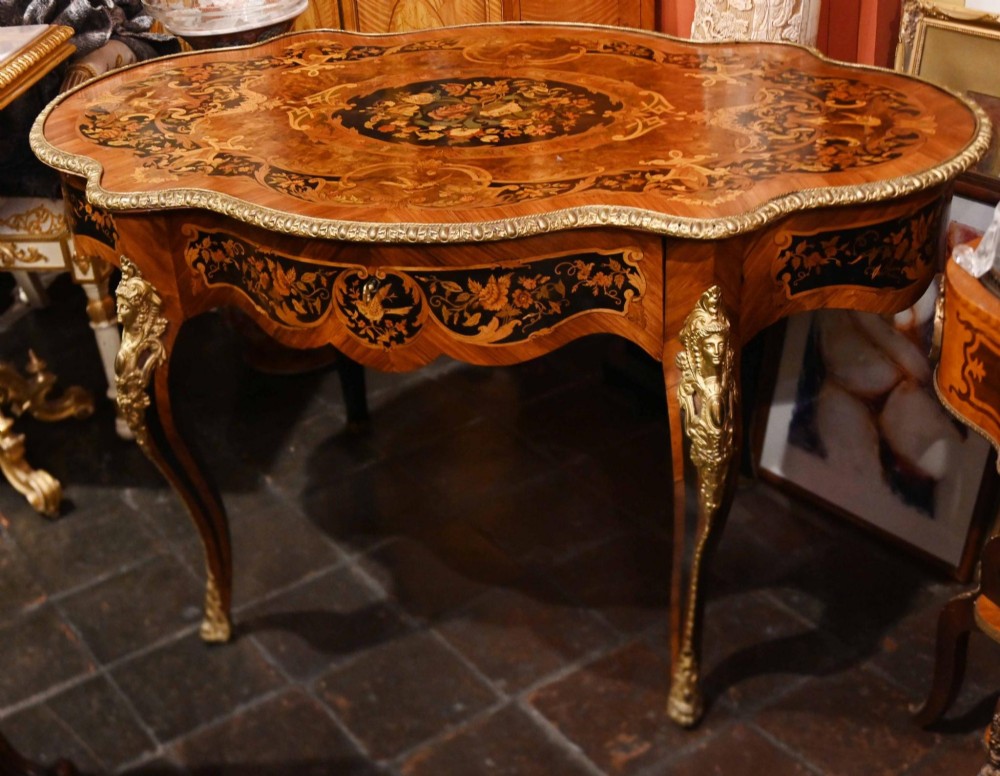 A French Louis XV style centre table featuring intricate floral marquetry, a serpentine top, cabriole legs, and gilded bronze mounts. View II