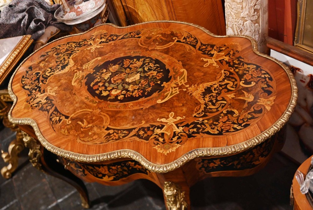 A French Louis XV style centre table featuring intricate floral marquetry, a serpentine top, cabriole legs, and gilded bronze mounts. View IV