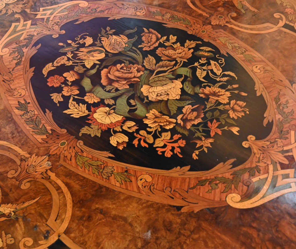 A French Louis XV style centre table featuring intricate floral marquetry, a serpentine top, cabriole legs, and gilded bronze mounts. View V