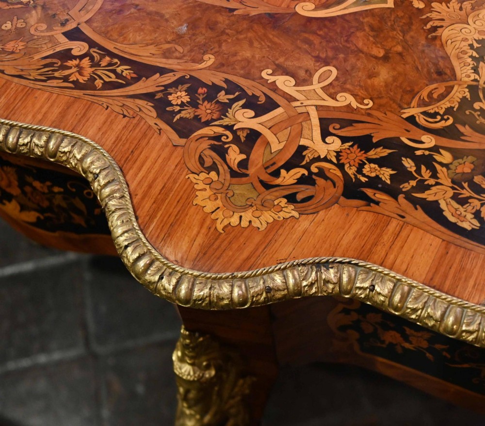 A French Louis XV style centre table featuring intricate floral marquetry, a serpentine top, cabriole legs, and gilded bronze mounts. View VII