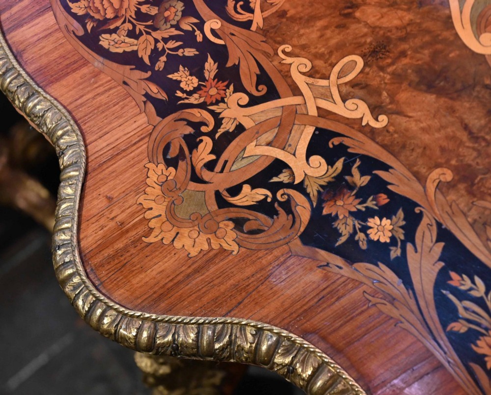 A French Louis XV style centre table featuring intricate floral marquetry, a serpentine top, cabriole legs, and gilded bronze mounts. View X