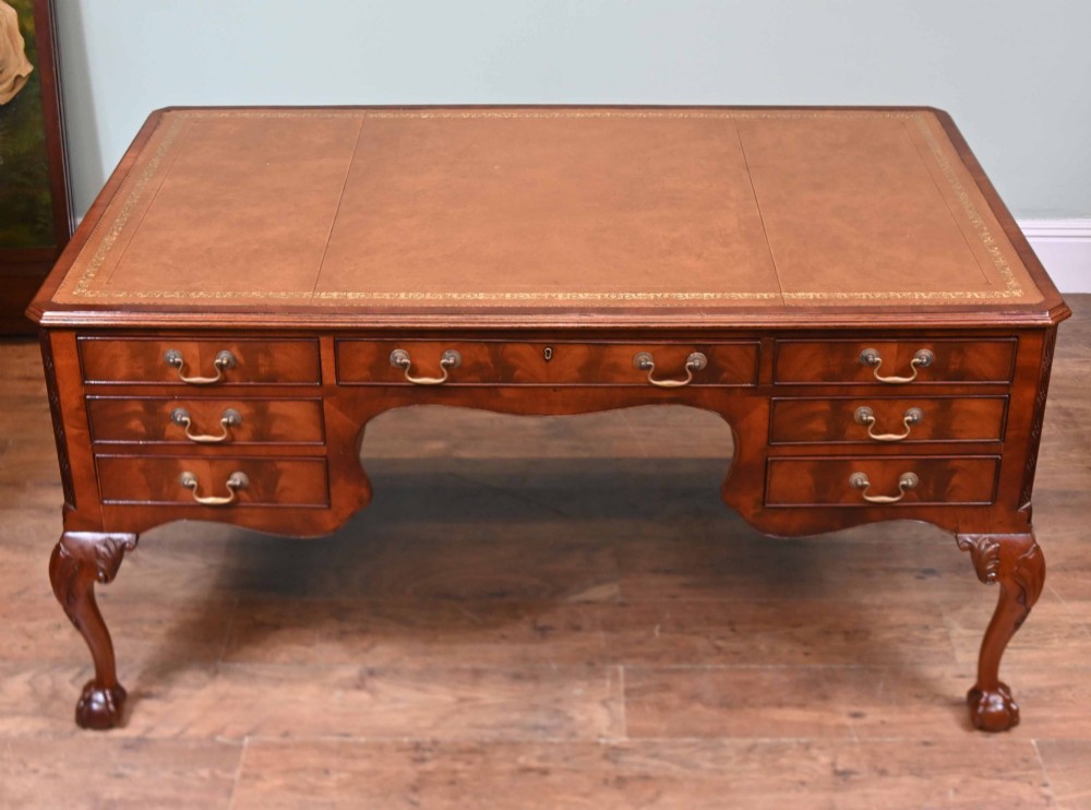 Late Victorian mahogany writing desk featuring a tan gilt-tooled leather inset top, brass swan-neck handles, and carved cabriole legs with ball-and-claw feet. View III