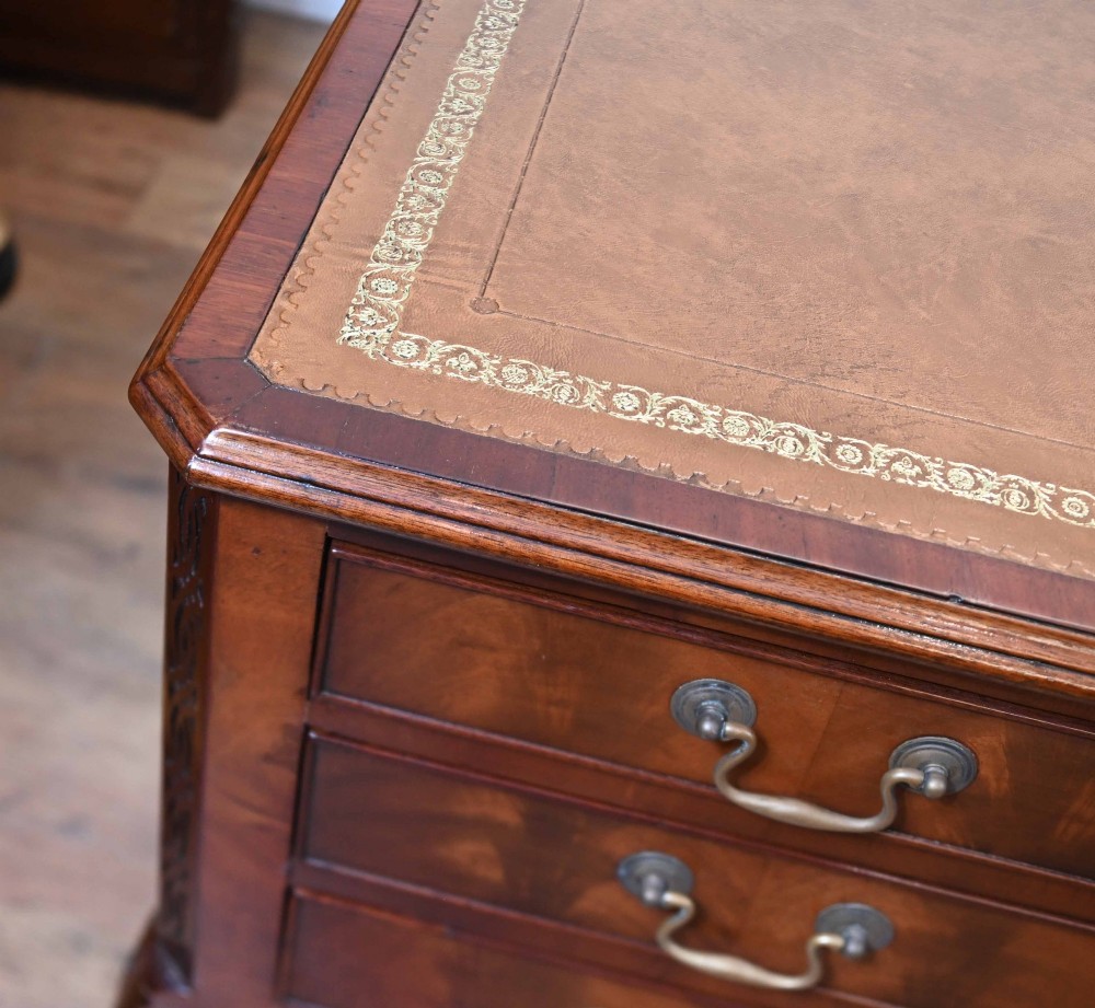 Late Victorian mahogany writing desk featuring a tan gilt-tooled leather inset top, brass swan-neck handles, and carved cabriole legs with ball-and-claw feet. View IV