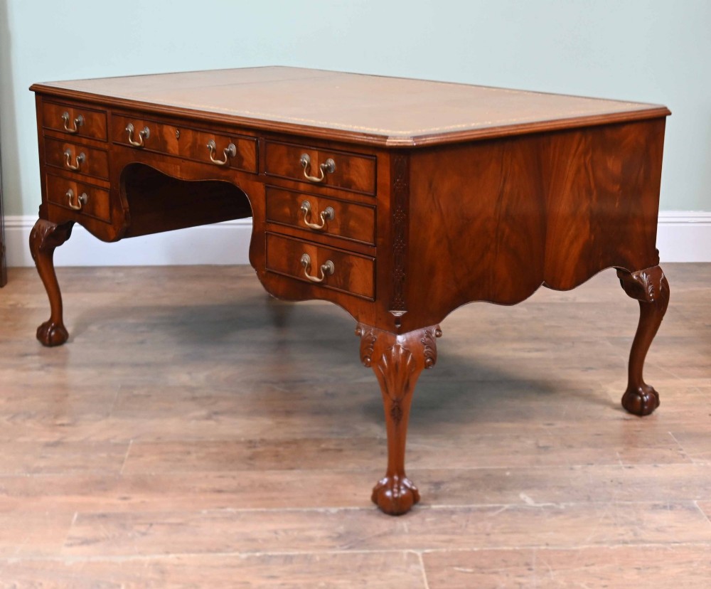 Late Victorian mahogany writing desk featuring a tan gilt-tooled leather inset top, brass swan-neck handles, and carved cabriole legs with ball-and-claw feet. View VII