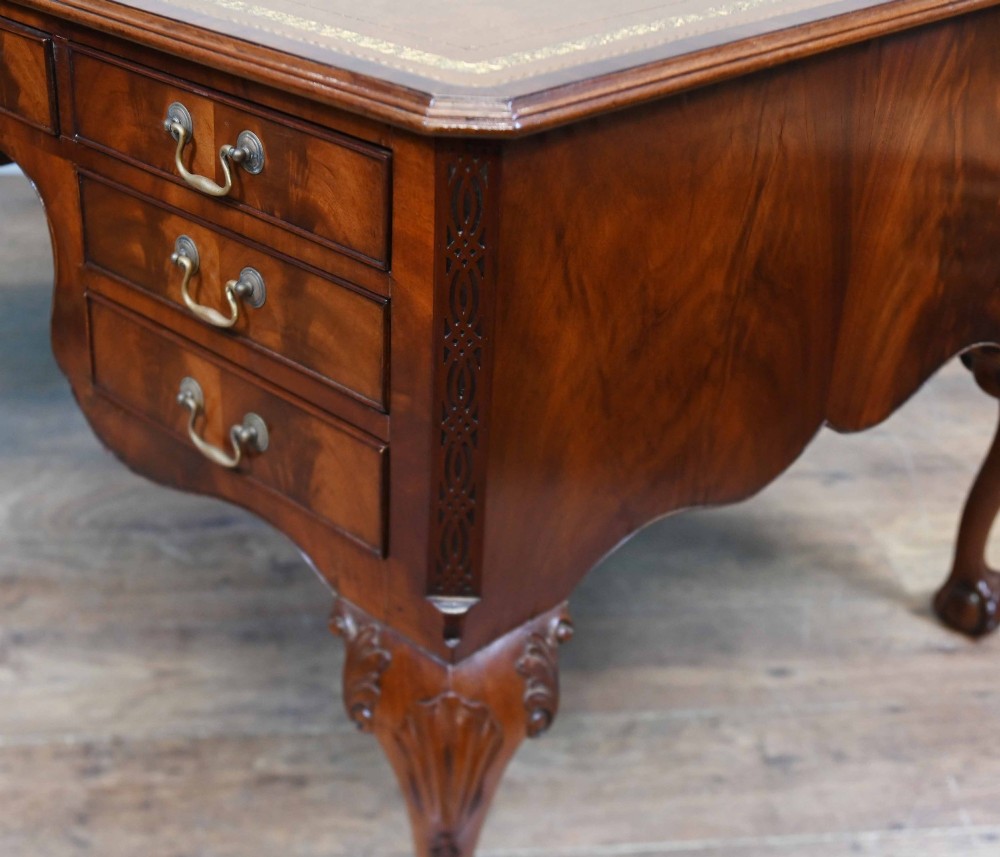Late Victorian mahogany writing desk featuring a tan gilt-tooled leather inset top, brass swan-neck handles, and carved cabriole legs with ball-and-claw feet. View VIII