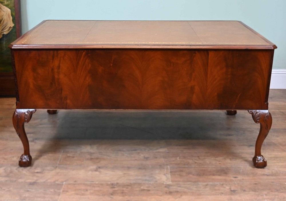 Late Victorian mahogany writing desk featuring a tan gilt-tooled leather inset top, brass swan-neck handles, and carved cabriole legs with ball-and-claw feet. View XI