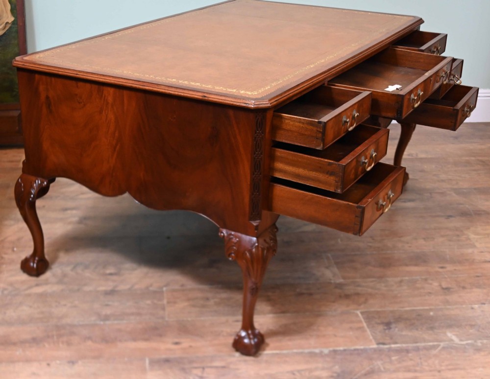 Late Victorian mahogany writing desk featuring a tan gilt-tooled leather inset top, brass swan-neck handles, and carved cabriole legs with ball-and-claw feet. View XII