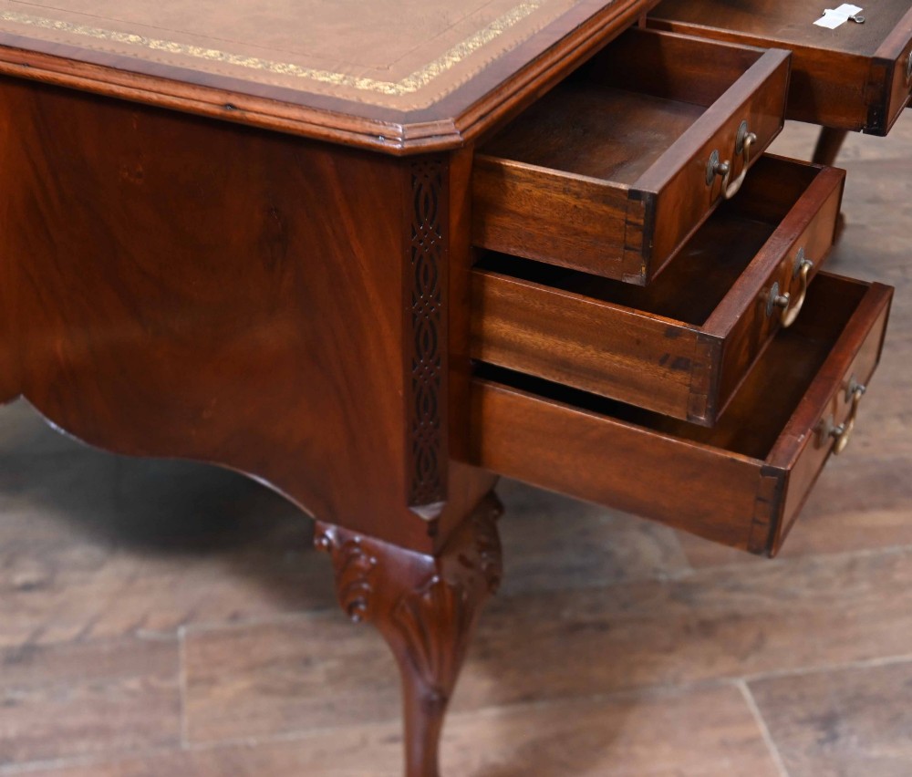 Late Victorian mahogany writing desk featuring a tan gilt-tooled leather inset top, brass swan-neck handles, and carved cabriole legs with ball-and-claw feet. View XIII