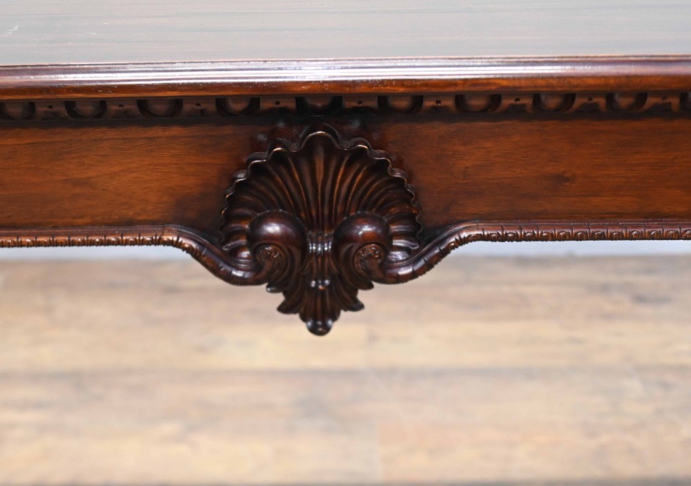 A rectangular Chippendale revival mahogany console table featuring a central carved apron shell detail, cabriole legs, and carved claw and ball feet. View V