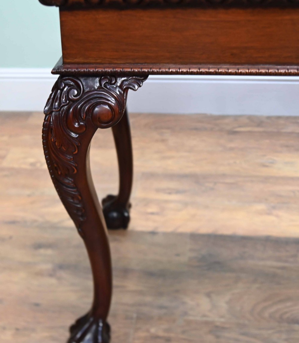 A rectangular Chippendale revival mahogany console table featuring a central carved apron shell detail, cabriole legs, and carved claw and ball feet. View VI