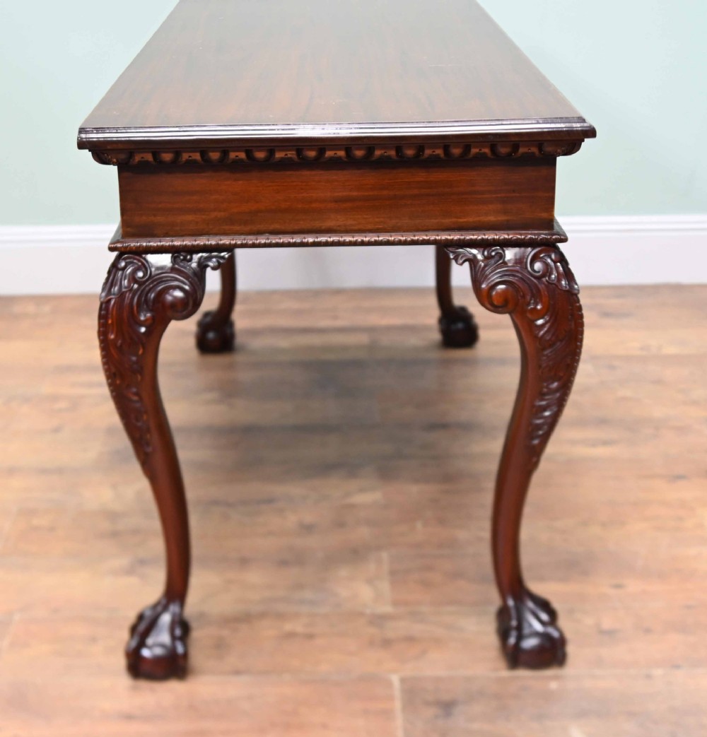 A rectangular Chippendale revival mahogany console table featuring a central carved apron shell detail, cabriole legs, and carved claw and ball feet. View X