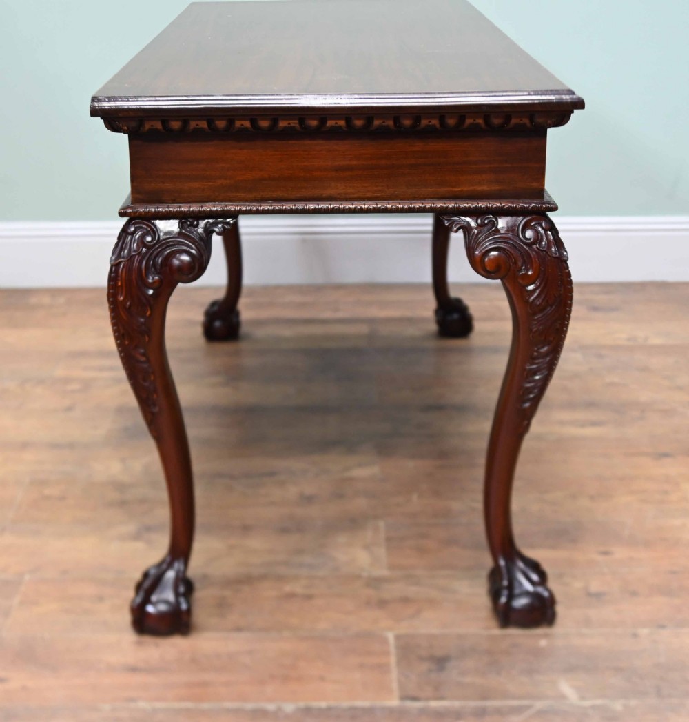 A rectangular Chippendale revival mahogany console table featuring a central carved apron shell detail, cabriole legs, and carved claw and ball feet. View XI