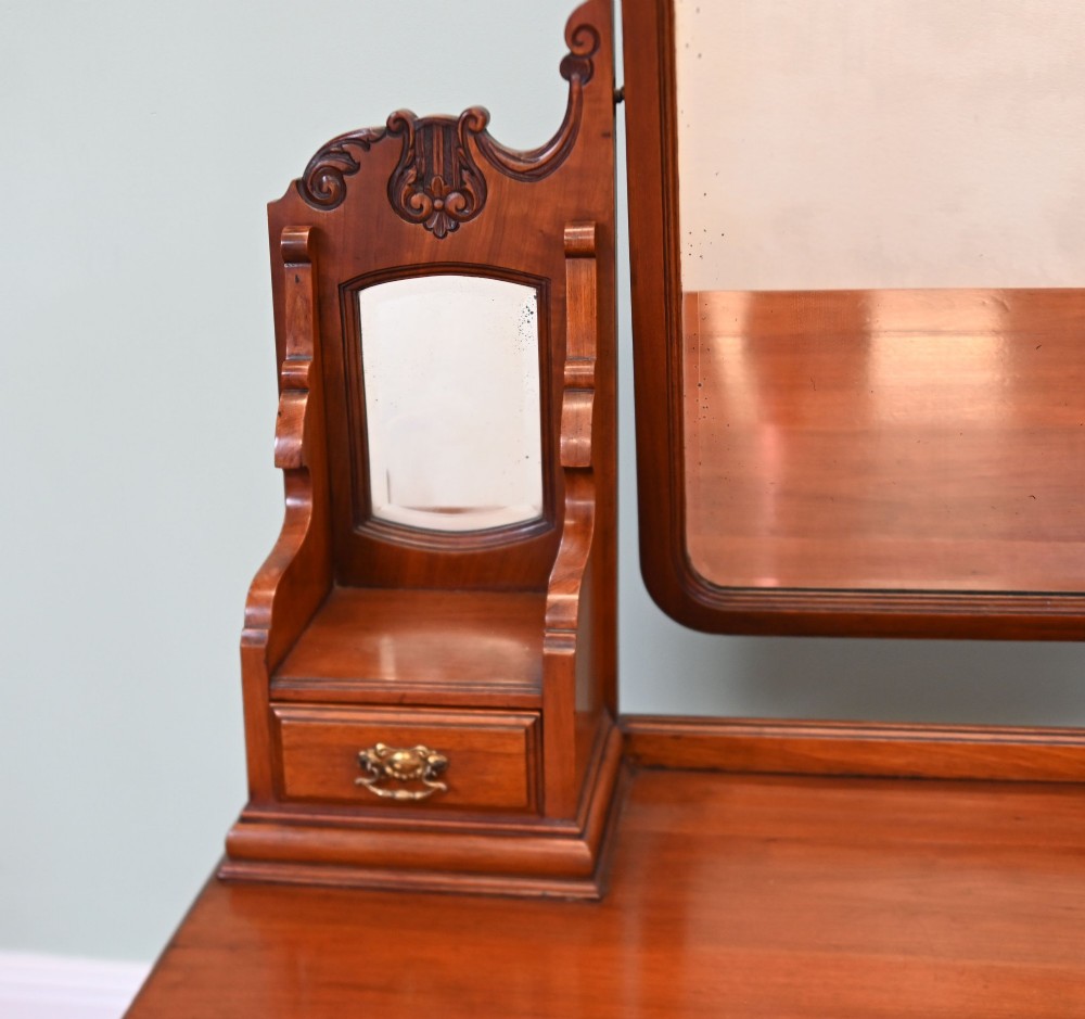 An Edwardian mahogany dressing table featuring a central swinging mirror flanked by two trinket drawers, set above a chest with three drawers and brass drop handles. View IV