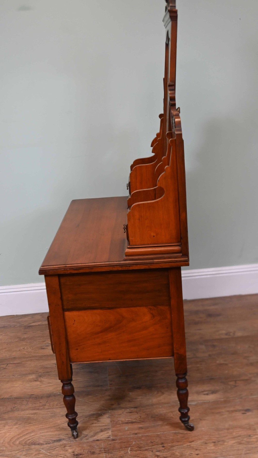 An Edwardian mahogany dressing table featuring a central swinging mirror flanked by two trinket drawers, set above a chest with three drawers and brass drop handles. View XIII