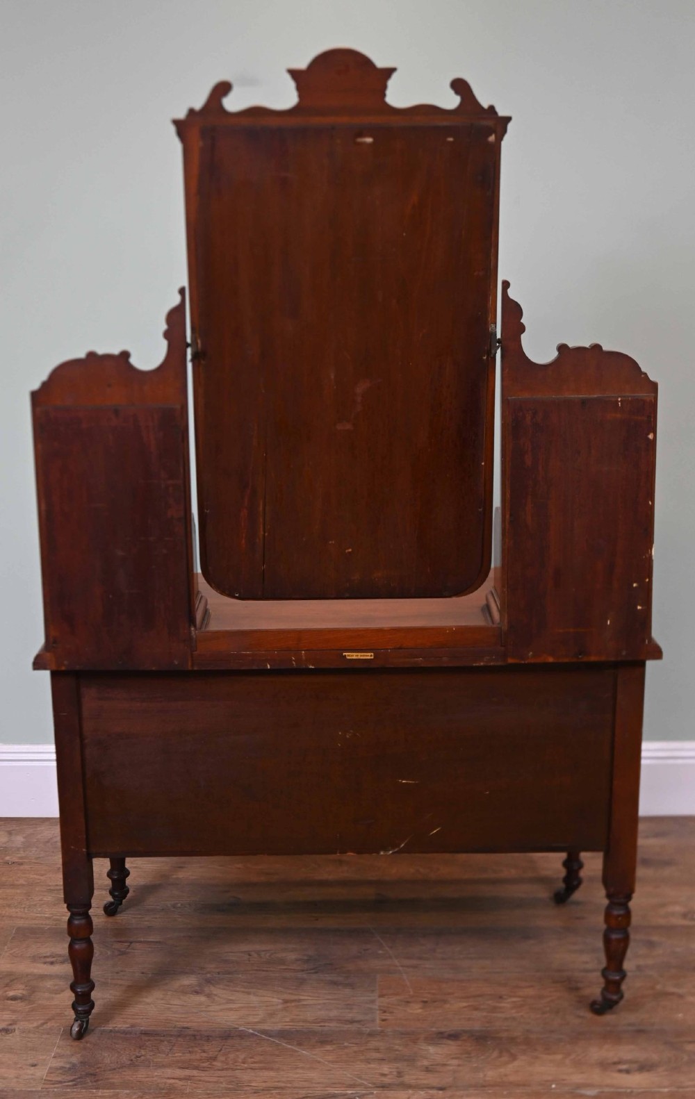 An Edwardian mahogany dressing table featuring a central swinging mirror flanked by two trinket drawers, set above a chest with three drawers and brass drop handles. View XIV