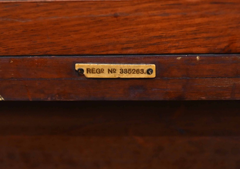 An Edwardian mahogany dressing table featuring a central swinging mirror flanked by two trinket drawers, set above a chest with three drawers and brass drop handles. View XV