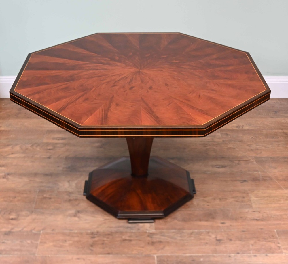 An octagonal Art Deco mahogany centre table featuring a sunburst veneer top, banded rim, and a tapered hexagonal pedestal base. View IV