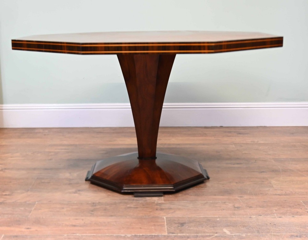 An octagonal Art Deco mahogany centre table featuring a sunburst veneer top, banded rim, and a tapered hexagonal pedestal base. View V