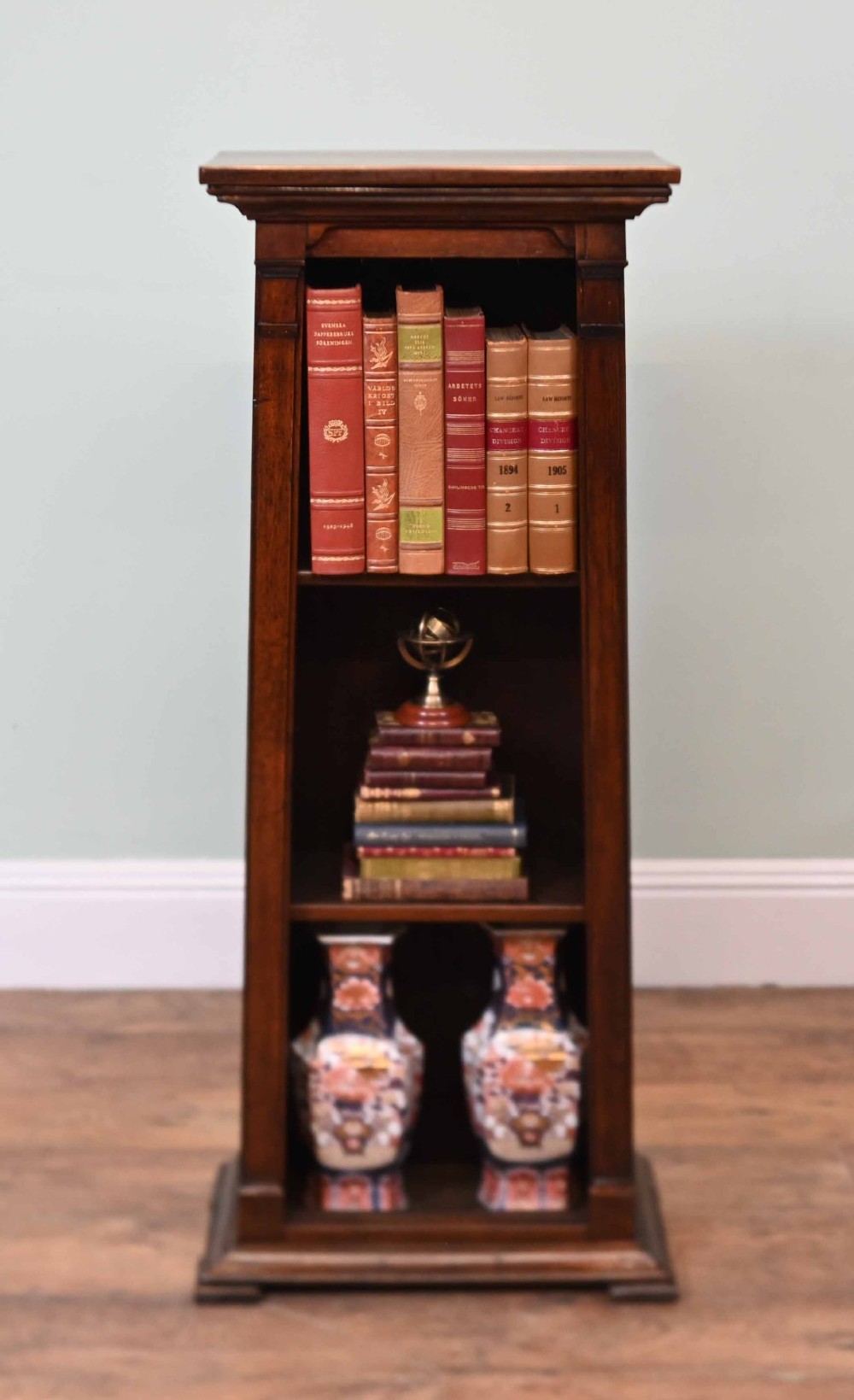 A tall, narrow late 19th-century dark oak open bookcase featuring fixed shelves, a moulded top cornice, and a sturdy plinth base. View II
