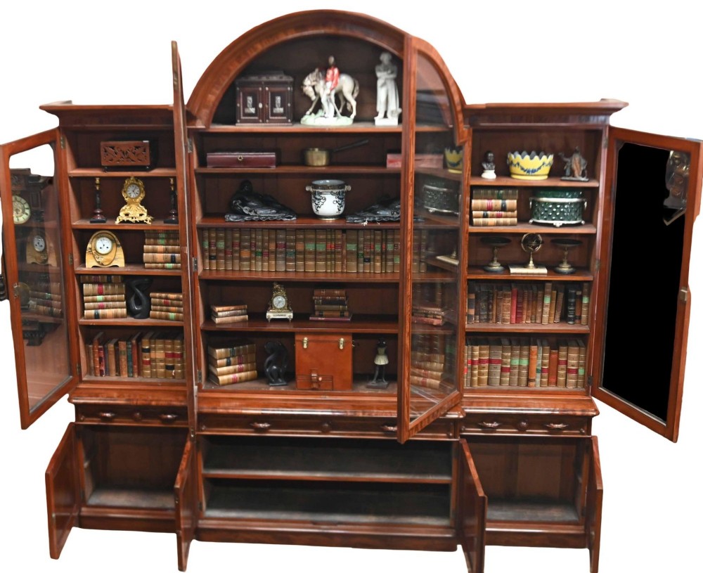 A large Victorian mahogany breakfront library bookcase featuring an arched central section with glazed upper doors over solid panelled cupboards. View II