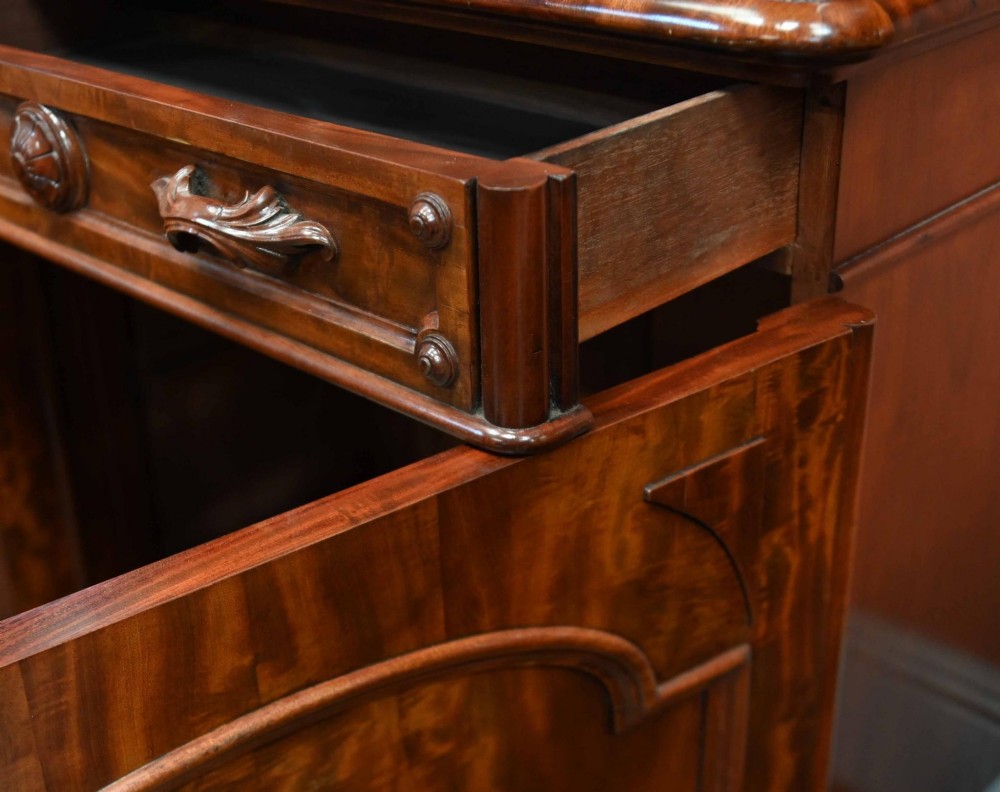 A large Victorian mahogany breakfront library bookcase featuring an arched central section with glazed upper doors over solid panelled cupboards. View VIII