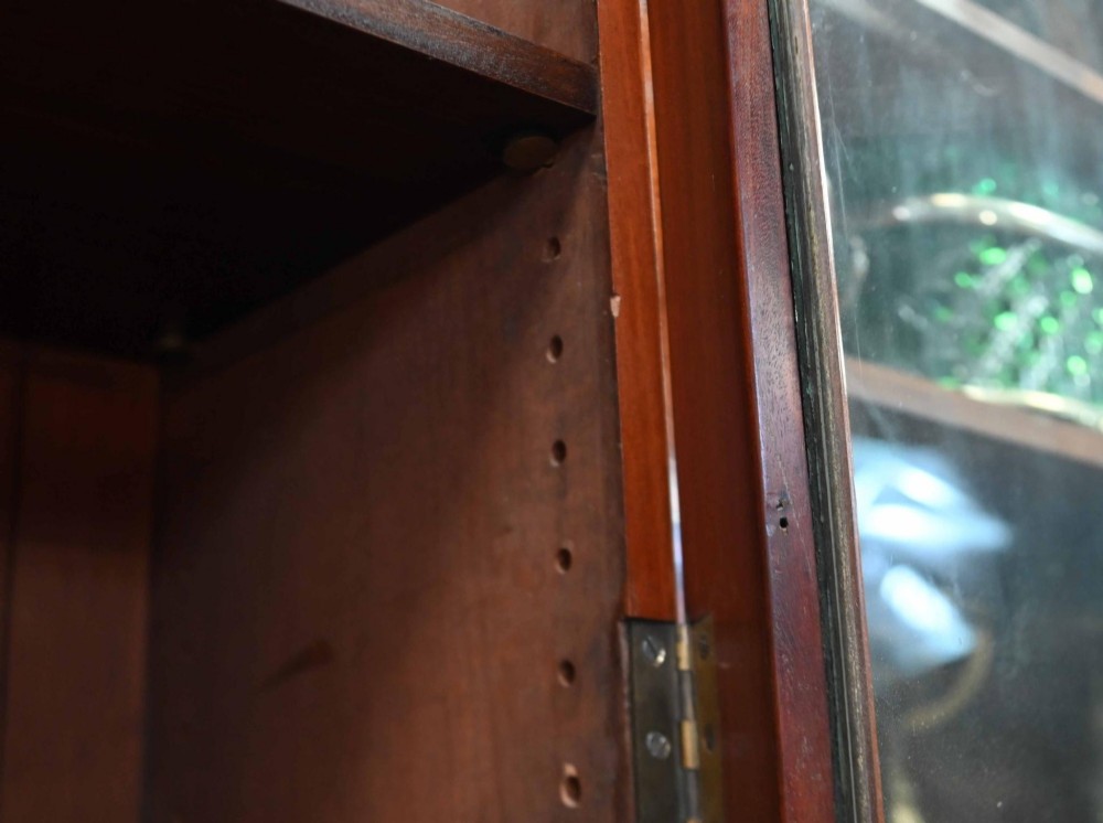 A large Victorian mahogany breakfront library bookcase featuring an arched central section with glazed upper doors over solid panelled cupboards. View XII