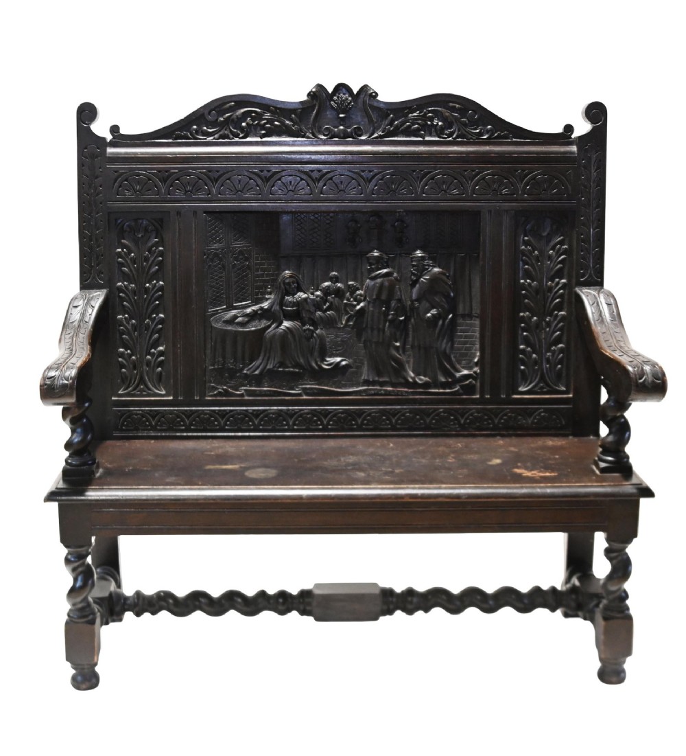 A late 19th-century dark carved walnut hall bench featuring a pictorial relief back panel, scrolled armrests, and turned stretchers. View VII
