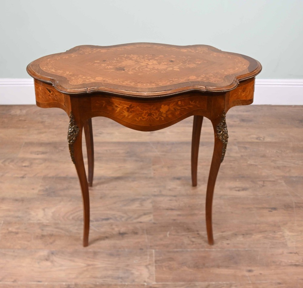 A shaped French Louis XV style writing table crafted from warm brown wood featuring intricate floral marquetry inlay, cabriole legs, and bronze mounts. View V