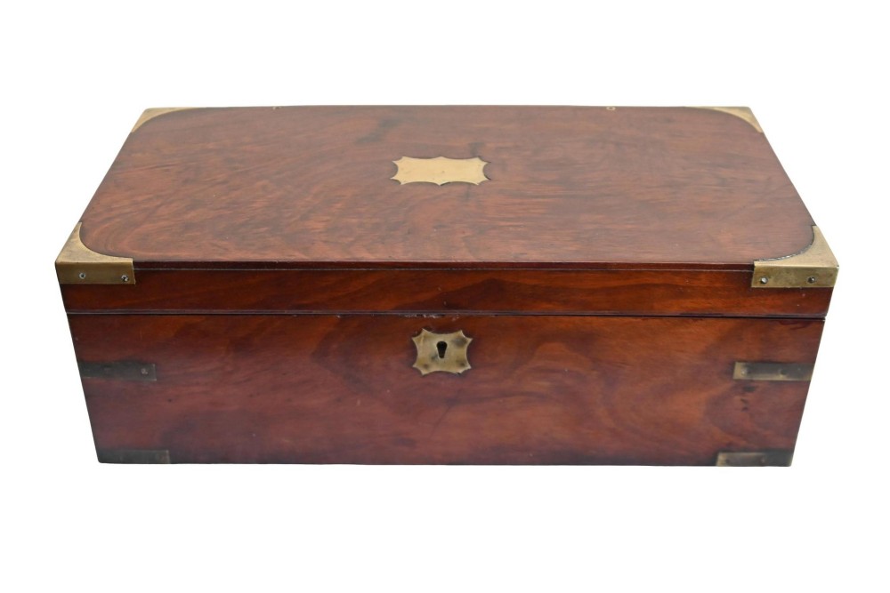 A rectangular warm brown mahogany wooden writing slope box featuring brass corner brackets and a shaped brass keyhole escutcheon.