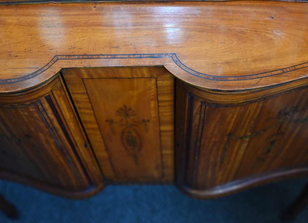 An Edwardian Sheraton Revival display cabinet in painted satinwood with glazed double doors, decorative oval glazing bars, and lower cupboard doors on slender square legs. View X