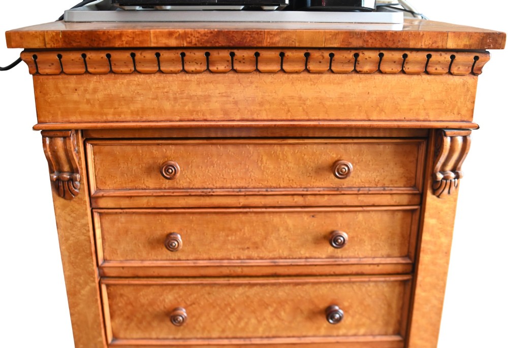 A tall Victorian birds eye maple Wellington chest featuring seven drawers with turned wooden knobs and a side locking flap. View II