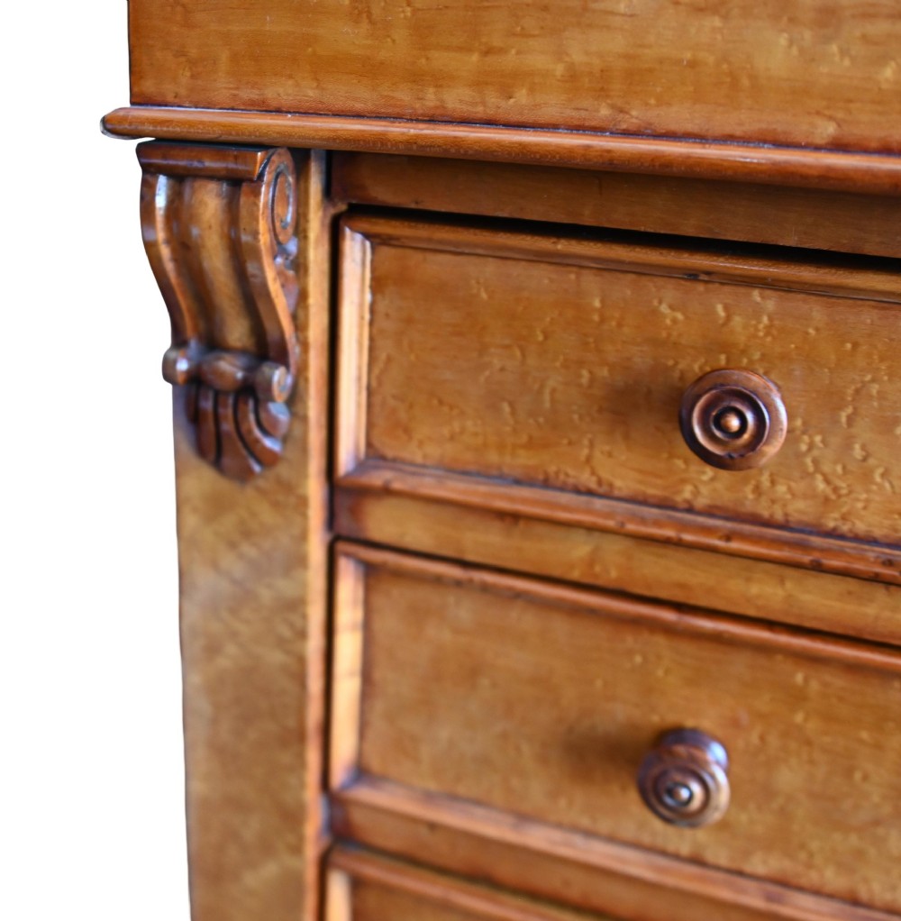 A tall Victorian birds eye maple Wellington chest featuring seven drawers with turned wooden knobs and a side locking flap. View V