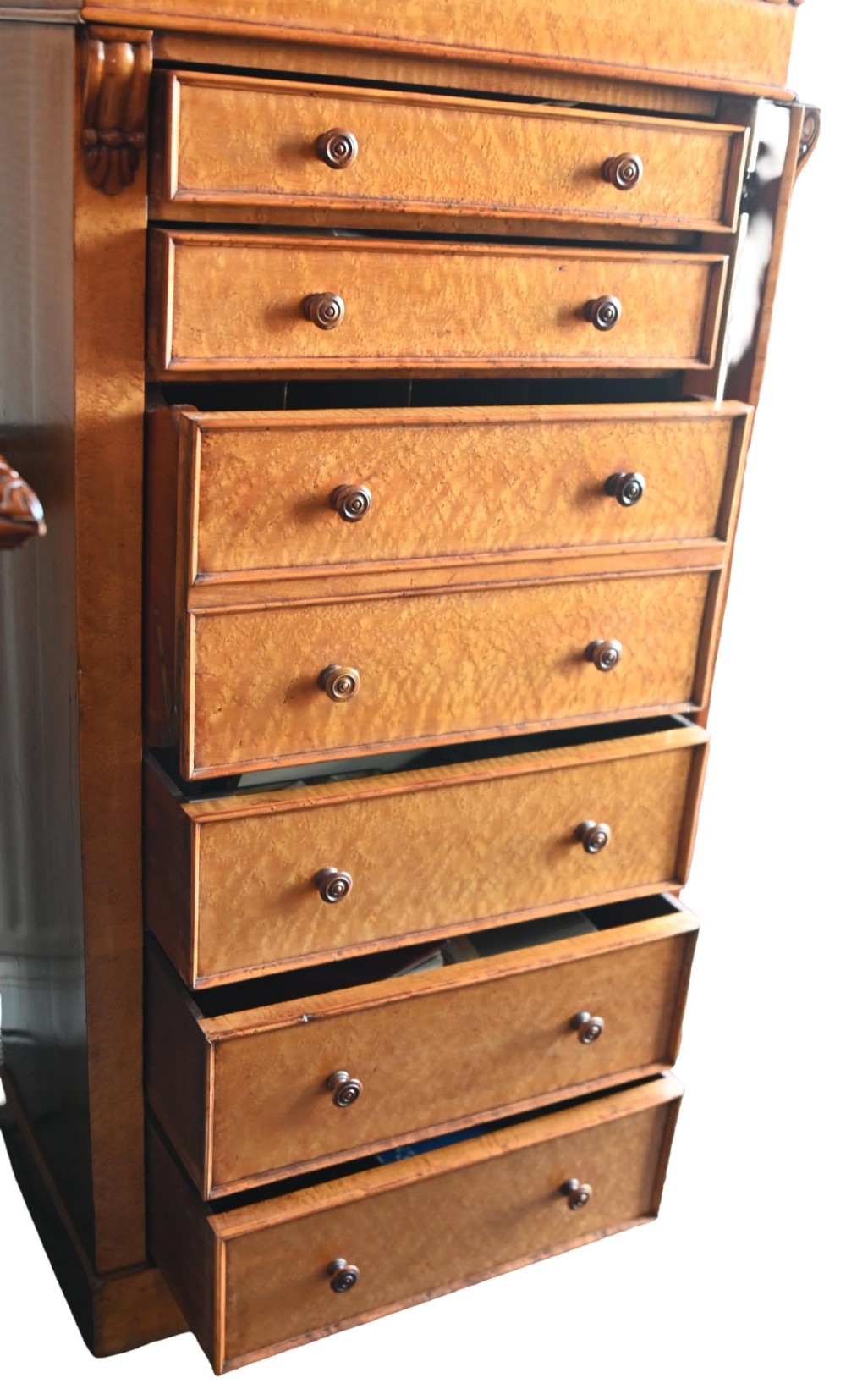 A tall Victorian birds eye maple Wellington chest featuring seven drawers with turned wooden knobs and a side locking flap. View IX