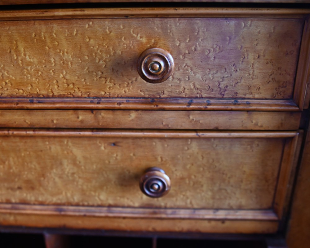 A tall Victorian birds eye maple Wellington chest featuring seven drawers with turned wooden knobs and a side locking flap. View XV
